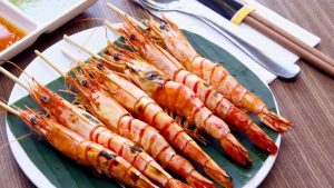 Skewered grilled prawns over charcoal at An Bang Beach Village Restaurant in An Bang Fishing Village, Hoi An